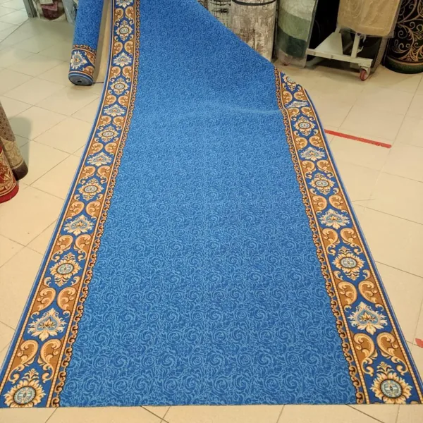 Blue patterned carpet runner with ornate gold borders.