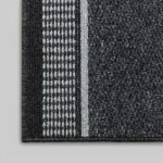 Close-up of black rug with white Greek key border