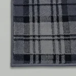 Close-up of grey plaid rug pattern and stitching