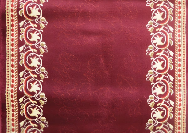 Cream floral borders on a maroon patterned rug