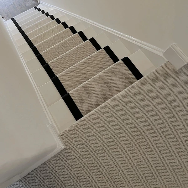Cream herringbone stair runner with black tape binding.