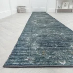 Distressed blue wool runner on a herringbone wood floor.