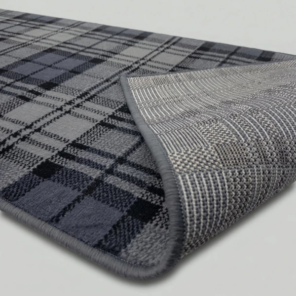 Grey tartan rug showing non-slip textured backing