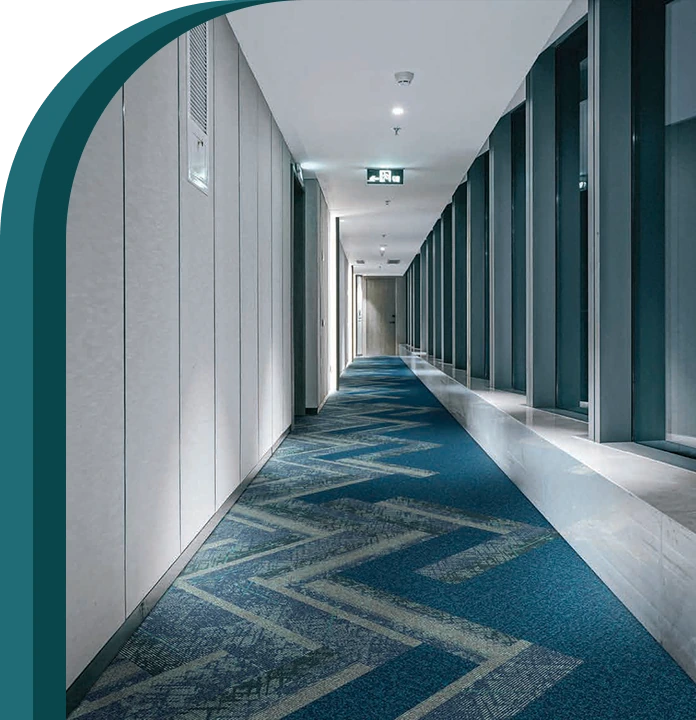 Modern blue chevron patterned carpet runner in a long office hallway.