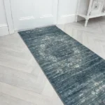 Modern grey chevron runner rug by a white door.