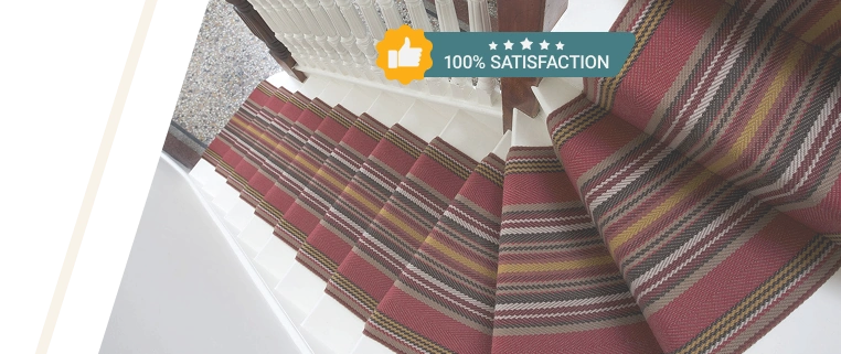 Red and tan striped carpet runner on a white staircase.