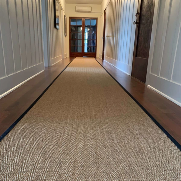 Woven sisal hallway runner with black border.